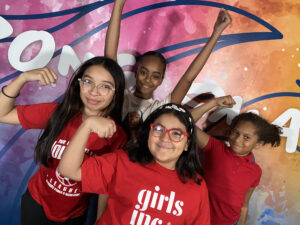 Group of four girls smiling and flexing
